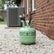 Green refrigerant tank on a gravel driveway with a brick building in the background