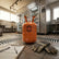 Orange refrigerant tank with 'R-404A' on a tiled floor in a kitchen setting.