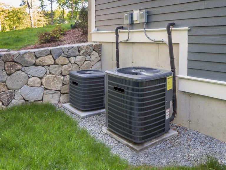 Two HVAC units beside a house.